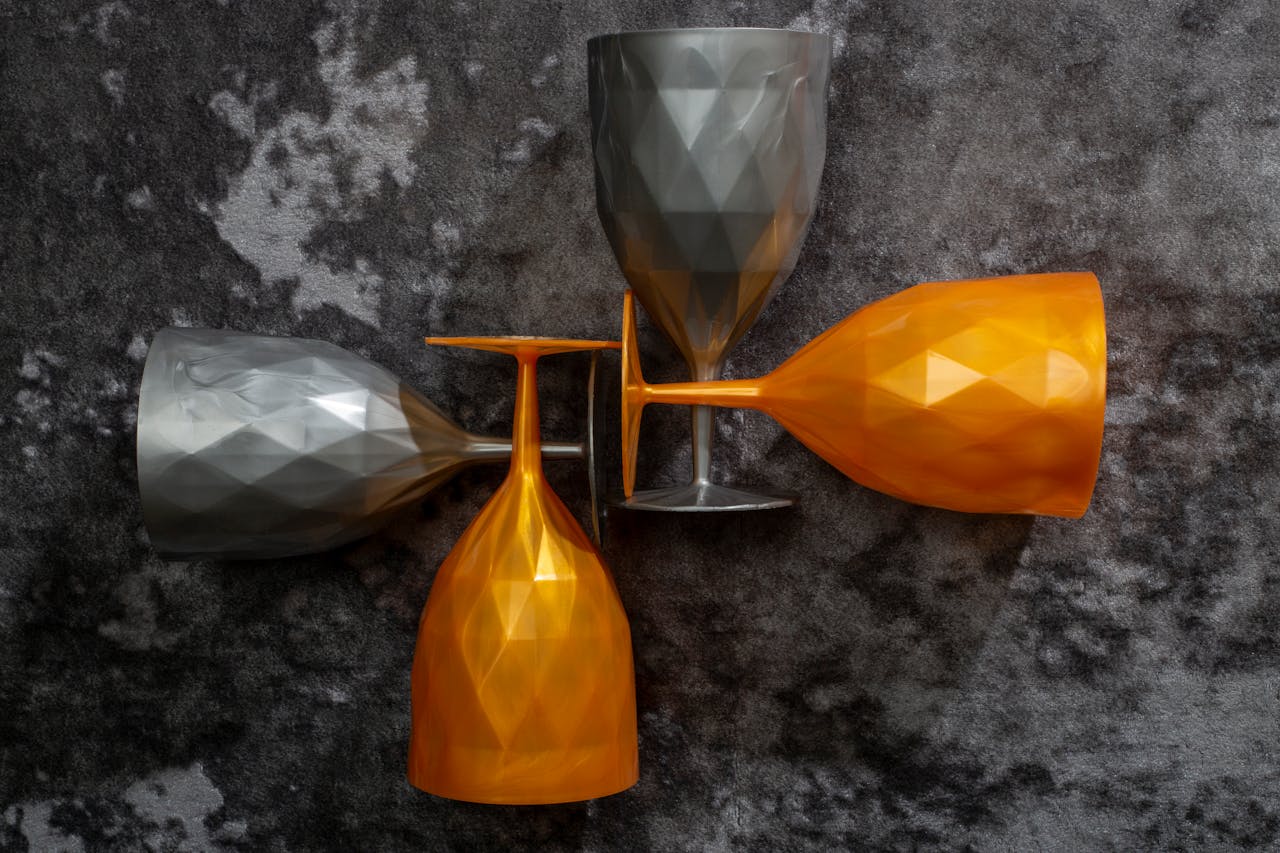 Elegant geometric wine glasses in orange and gray on a textured background, perfect for modern decor ideas.